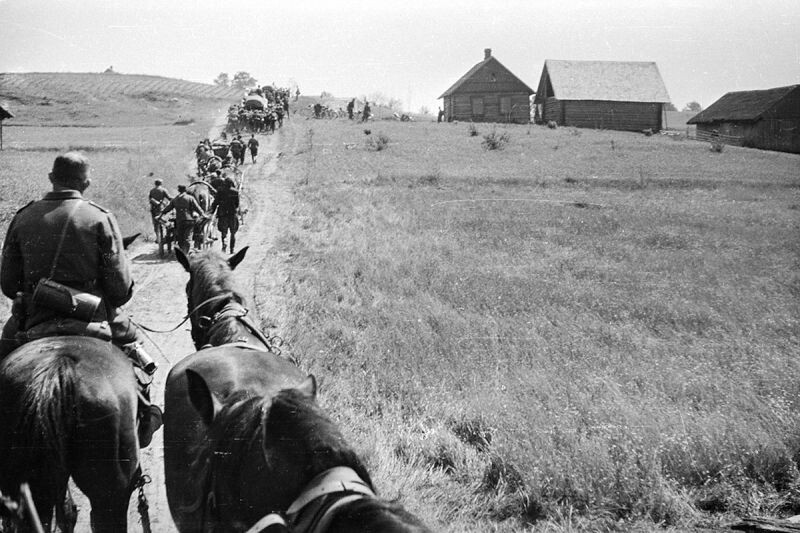 Немецкая колонна движется по дороге в советском селе. Июнь 1941 года