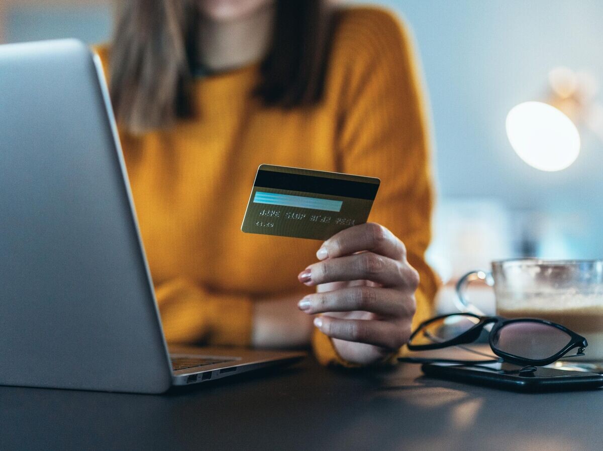    Девушка с банковской картой и ноутбуком | © iStock.com / filadendron