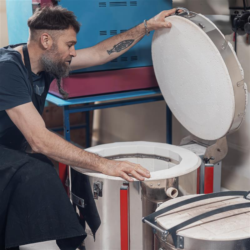 Преподаватель Школы-студии керамики Сергея Акентьева Группы компаний "Керамика Гжели", гончар Иван Безбородов загружает печь для обжига