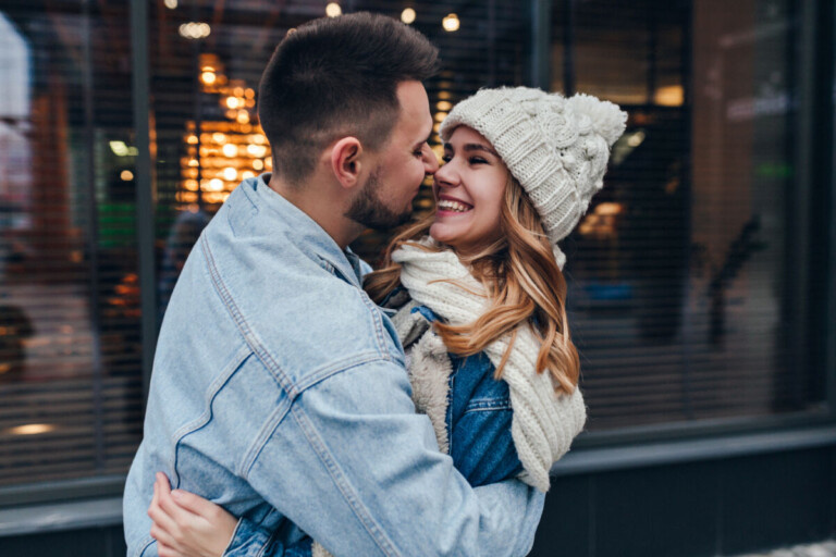    Stylish man in denim jacket embracing his girlfriend on urban background. Happy caucasian couple posing on the street during date. Надежда Дунаева