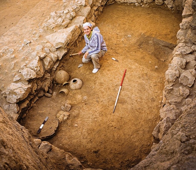 Археолог Элейн Салливан раскапывает захоронение № 4. Видны гончарные изделия и элементы ритуальных украшений.