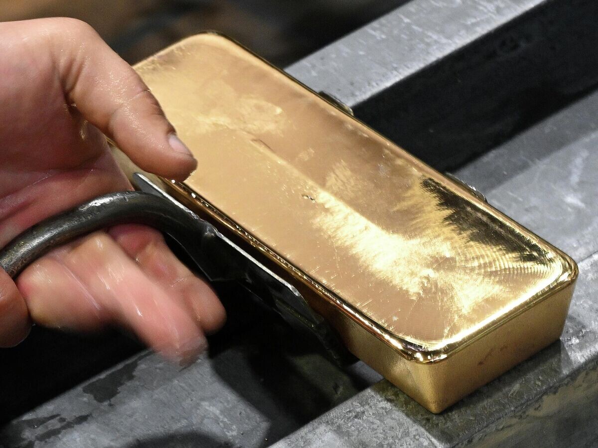    Металлург переносит горячий отлитый золотой слиток высшей пробы | © РИА Новости / Илья Наймушин