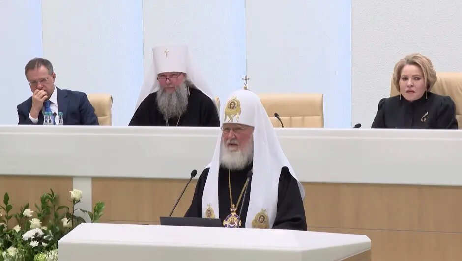    Патриарх Кирилл (за трибуной). Фото: скриншот из видео трансляции Совфеда.