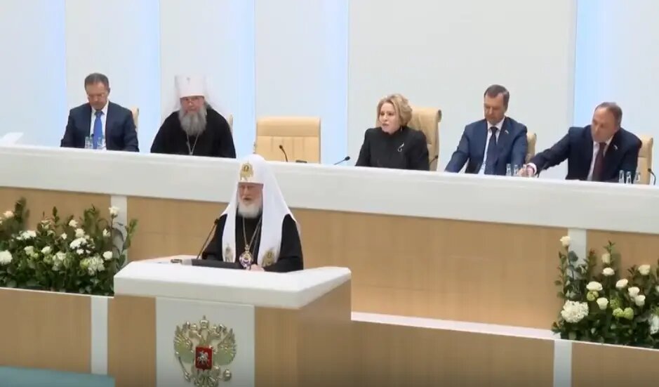    Патриарх Кирилл (за трибуной). Фото: скриншот из видео трансляции Совфеда.