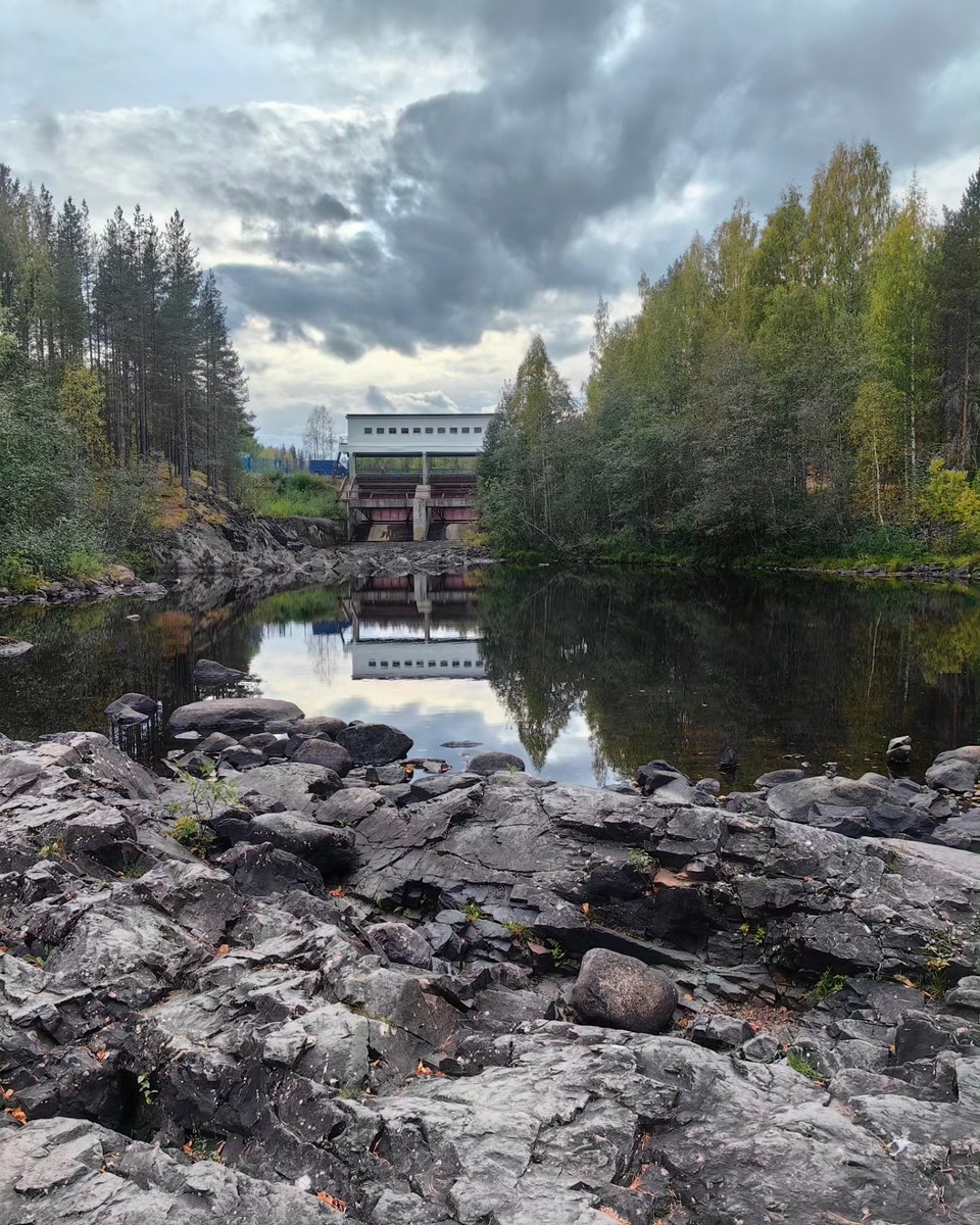 Вдали видна плотина, по ней проходит автомобильная дорога.