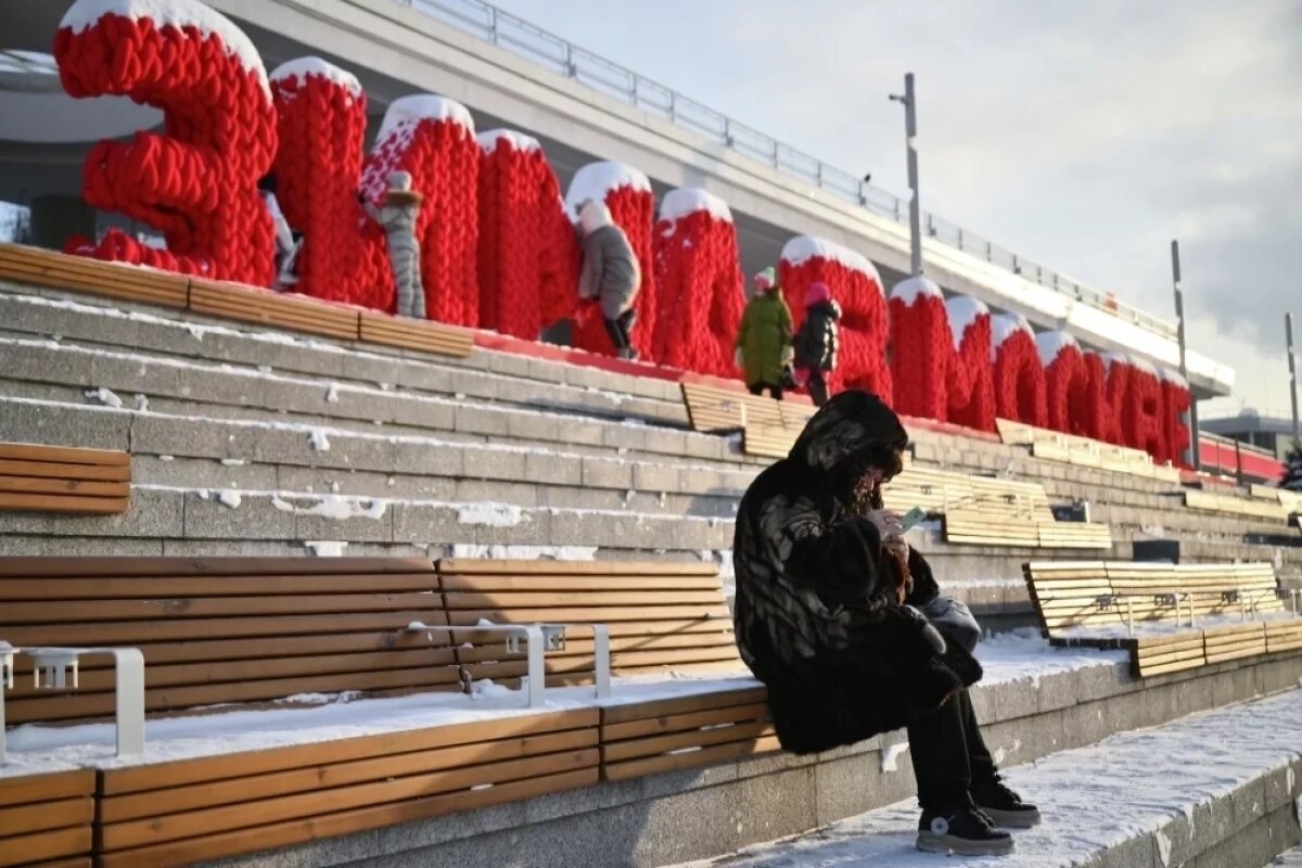     Женщина зимой на Крымской набережной в Москве.