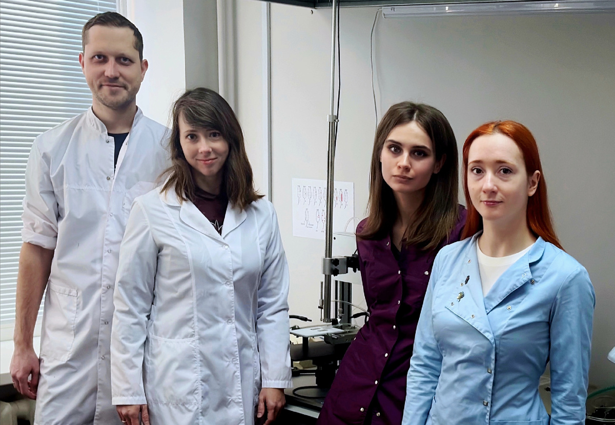 Фото авторов исследования на фоне установки для моделирования легкой ЧМТ. Источник: Юлия Кипрюшина