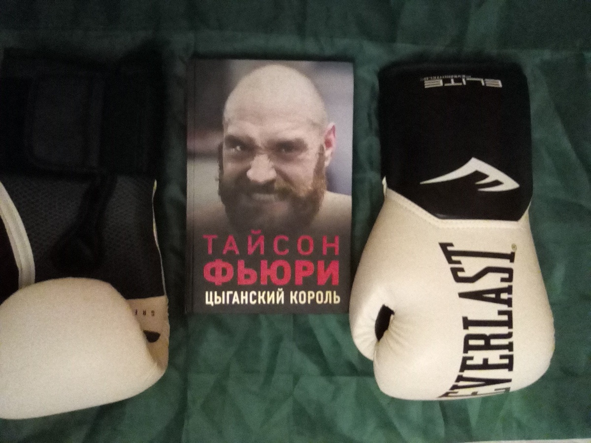 «Тайсон Фьюри: Цыганский король» Найджела Коуторна (издательство «Бомбора», 320 страниц, 2021). По бокам от книги боксёрские перчатки, выпущенные лучшим в мире производителем боксёрских перчаток 