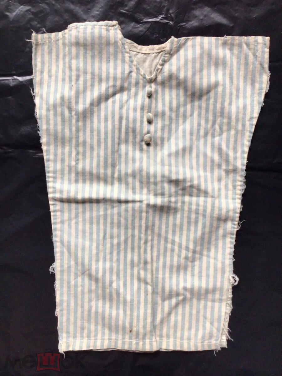 Платье из хлопчатобумажной ткани, сшитое по моде 1920-х годов в стиле ар-деко. Впереди три декоративные пуговицы, обтянутые основным материалом. Предназначено на куклу высотой примерно 55-65 см. Источник фото: https://meshok.net/item/302719737_%D0%9F%D0%BB%D0%B0%D1%82%D1%8C%D0%B5_%D0%B4%D0%BB%D1%8F_%D0%B0%D0%BD%D1%82%D0%B8%D0%BA%D0%B2%D0%B0%D1%80%D0%BD%D0%BE%D0%B9_%D0%BA%D1%83%D0%BA%D0%BB%D1%8B_%D0%9C%D0%BE%D0%B4%D0%B0_%D1%8D%D0%BF%D0%BE%D1%85%D0%B8_%D0%9D%D0%AD%D0%9F%D0%B0