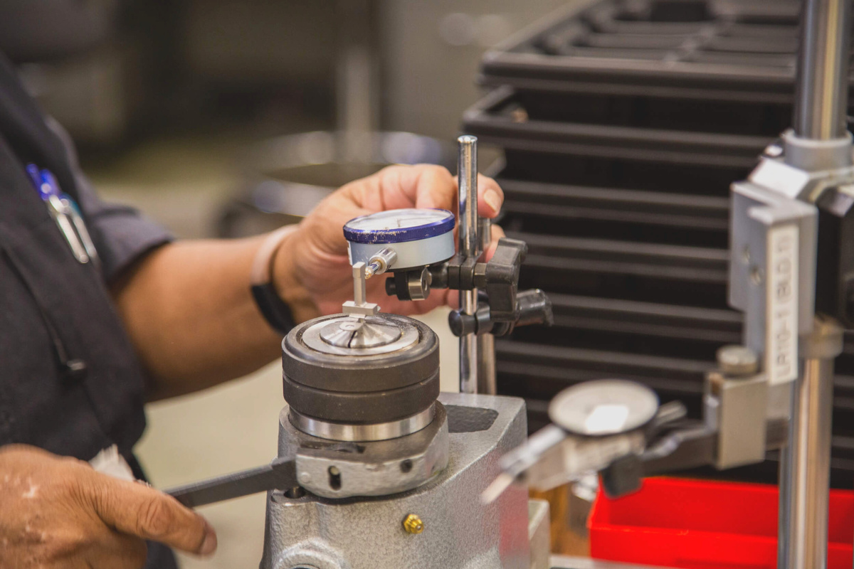 Высокоточное измерение и контроль качества деталей с помощью индикатора часового типа в производственной лаборатории.