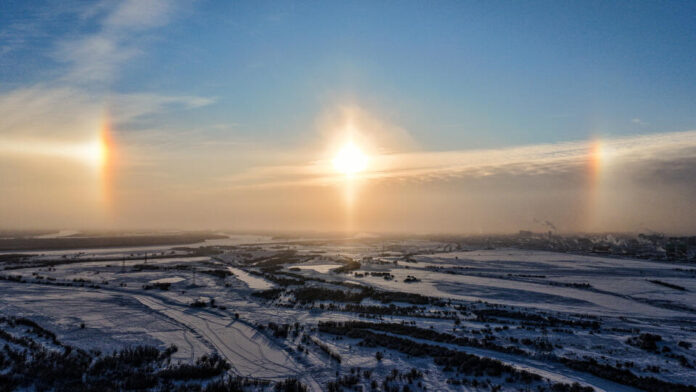    Фантазийное изображение: ледяная призма и три ярких солнца в зимнем небе в 2032 году