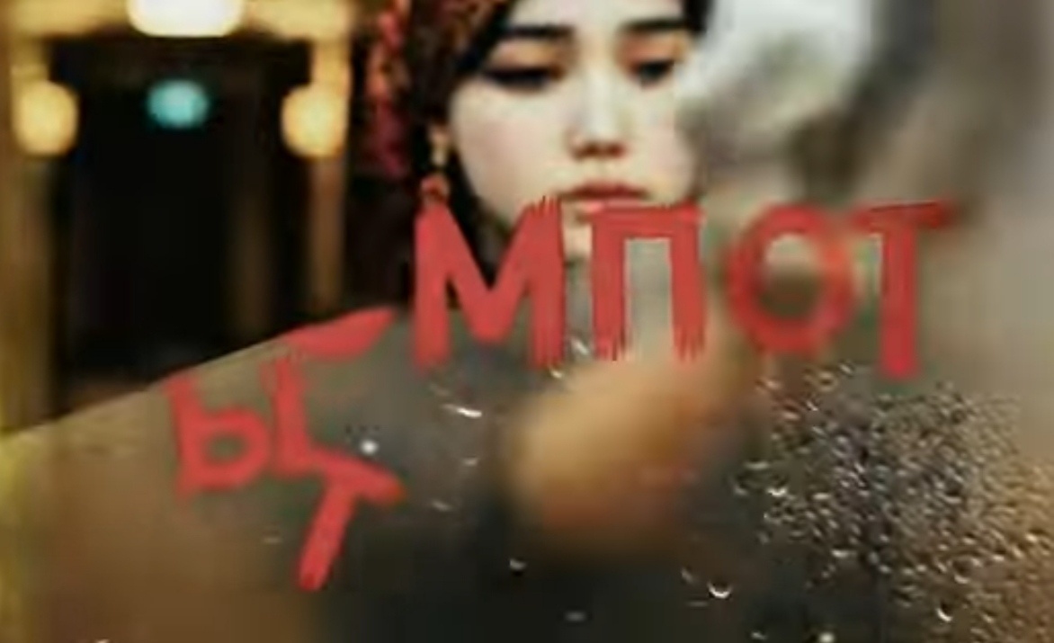 Кадр из клипа: Гуля якобы смывает надпись "Бахыт-компот", оставленную фанатами