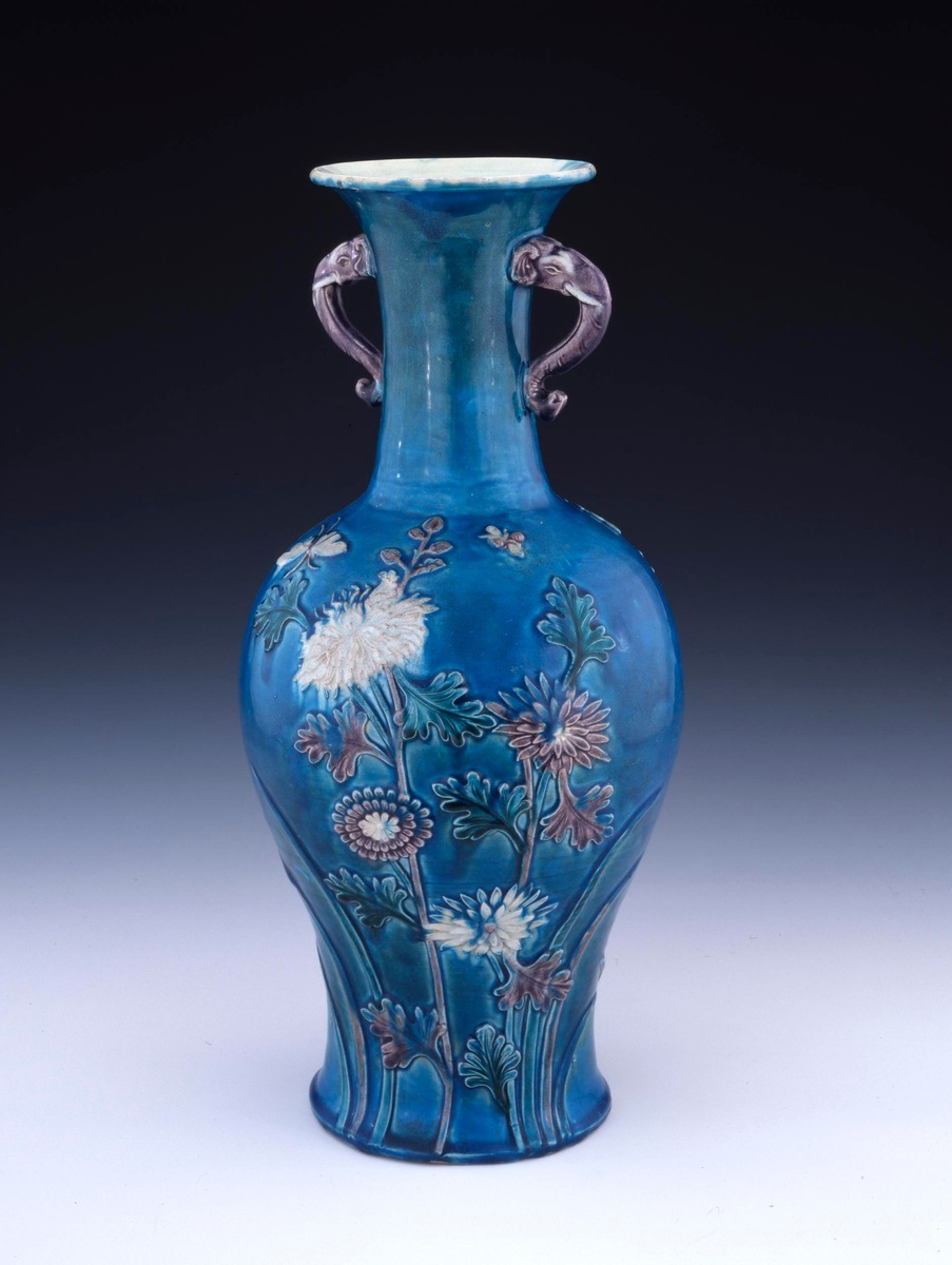 Ваза, изготовленная в печи Цзиндэчжэнь во времена династии Мин и хранящаяся в Британском музее. Ваза имеет длинное горлышко (высота 45,80 см), вывернутое наизнанку основание. Ваза украшена неглубоким рельефом: длинные стебли хризантем, тянущиеся и распускающиеся снизу, и бабочка и пчела, летящие над ними. Четыре цвета эмали — синий, красный, белый и зеленый — создают типичный для этого времени цветовой эффект. Внутренняя часть и дно вазы покрыты желтой глазурью. Фарфоровое искусство и техника росписи эмалью фахуа династии Мин внесли свой вклад в технологию изготовления фарфора в Цзиндэчжэне.