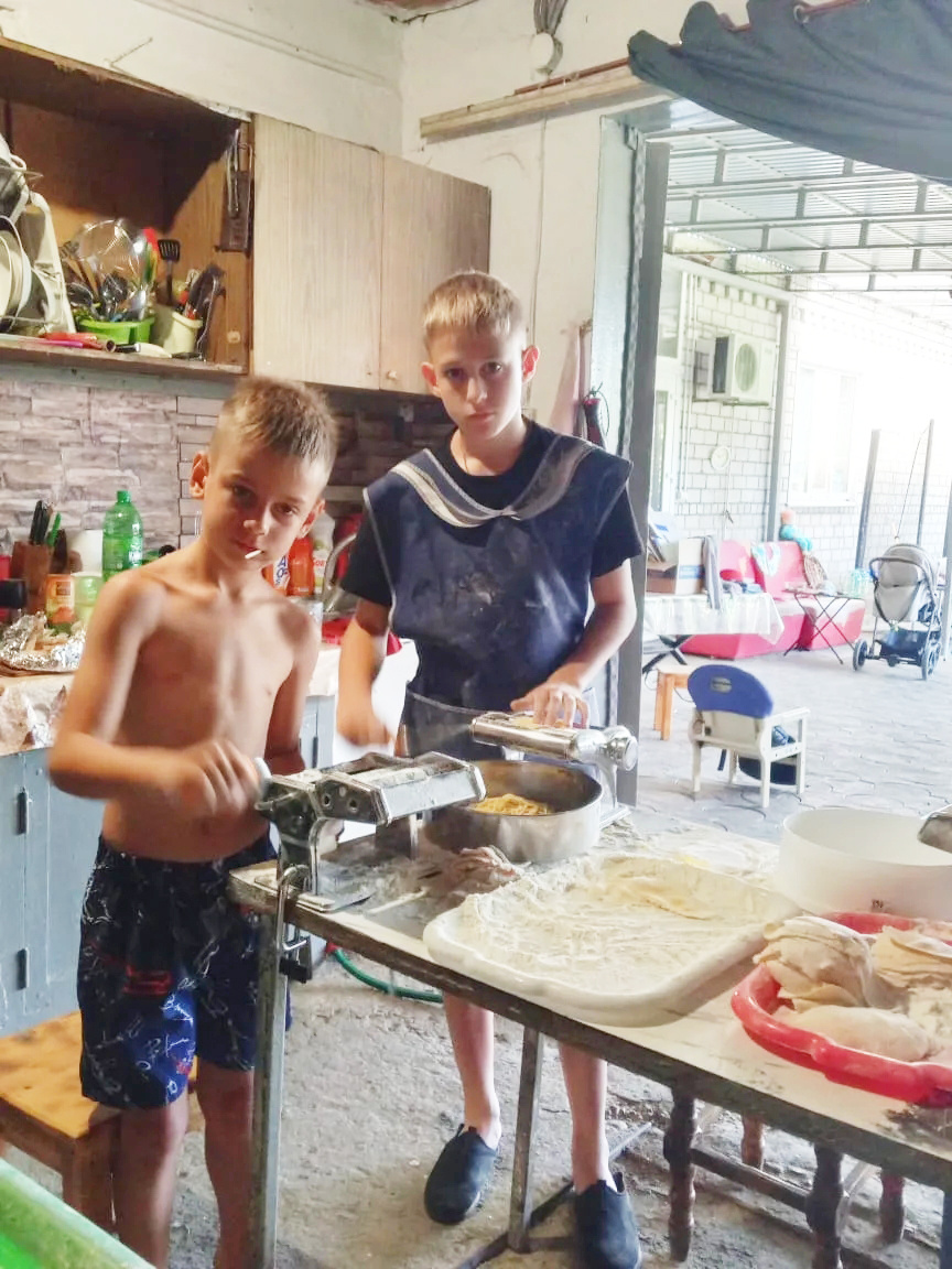    Витя и Вадим Пискаревы помогают катать лапшу. Витин отец, Андрей Пискарев, сейчас служит в зоне СВО / фото из архива Пискаревых