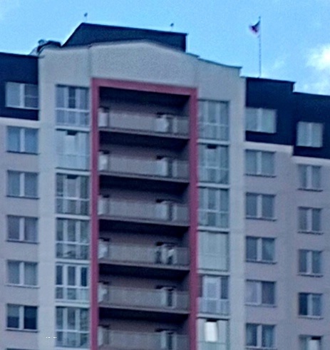 Госудврственный флаг над обычной многоэтажкой.