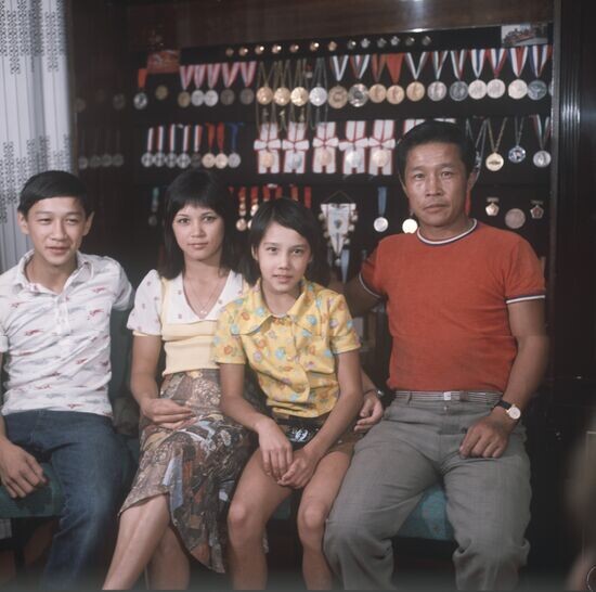 Нелли Ким с семьей отцом, братом и сестрой на фоне наград. Источник: https://img.riamediabank.ru