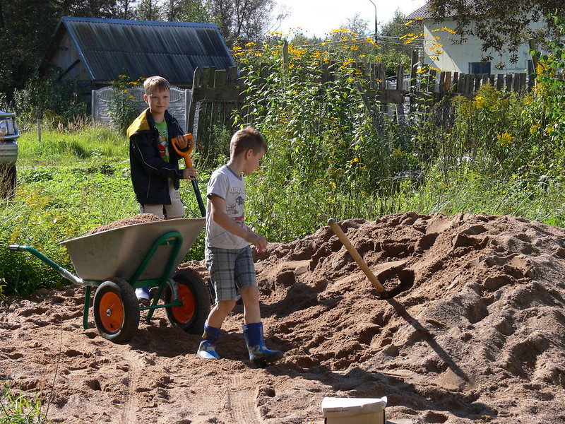 Мальцы закапывают сливную трубу