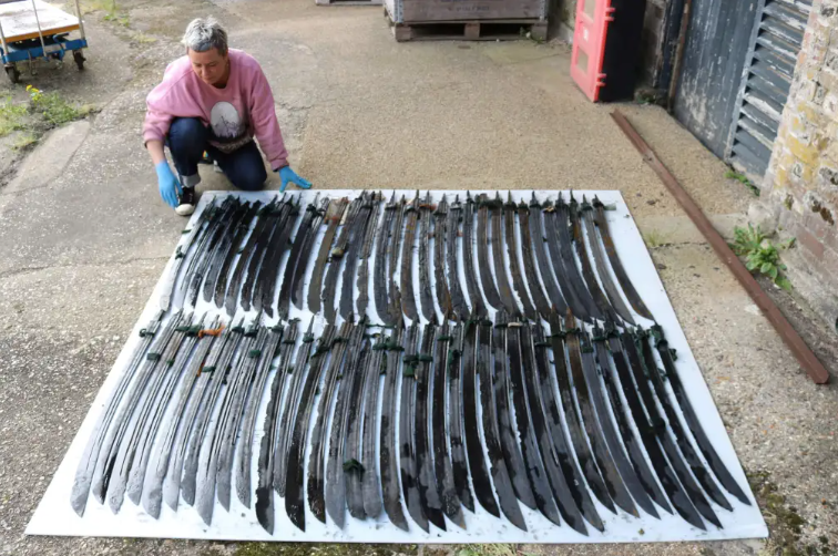 Реставратор Карола Дель Мезе с клинками сабель, извлеченными из сундуков, найденных в обломках корабля « Роосвейк»