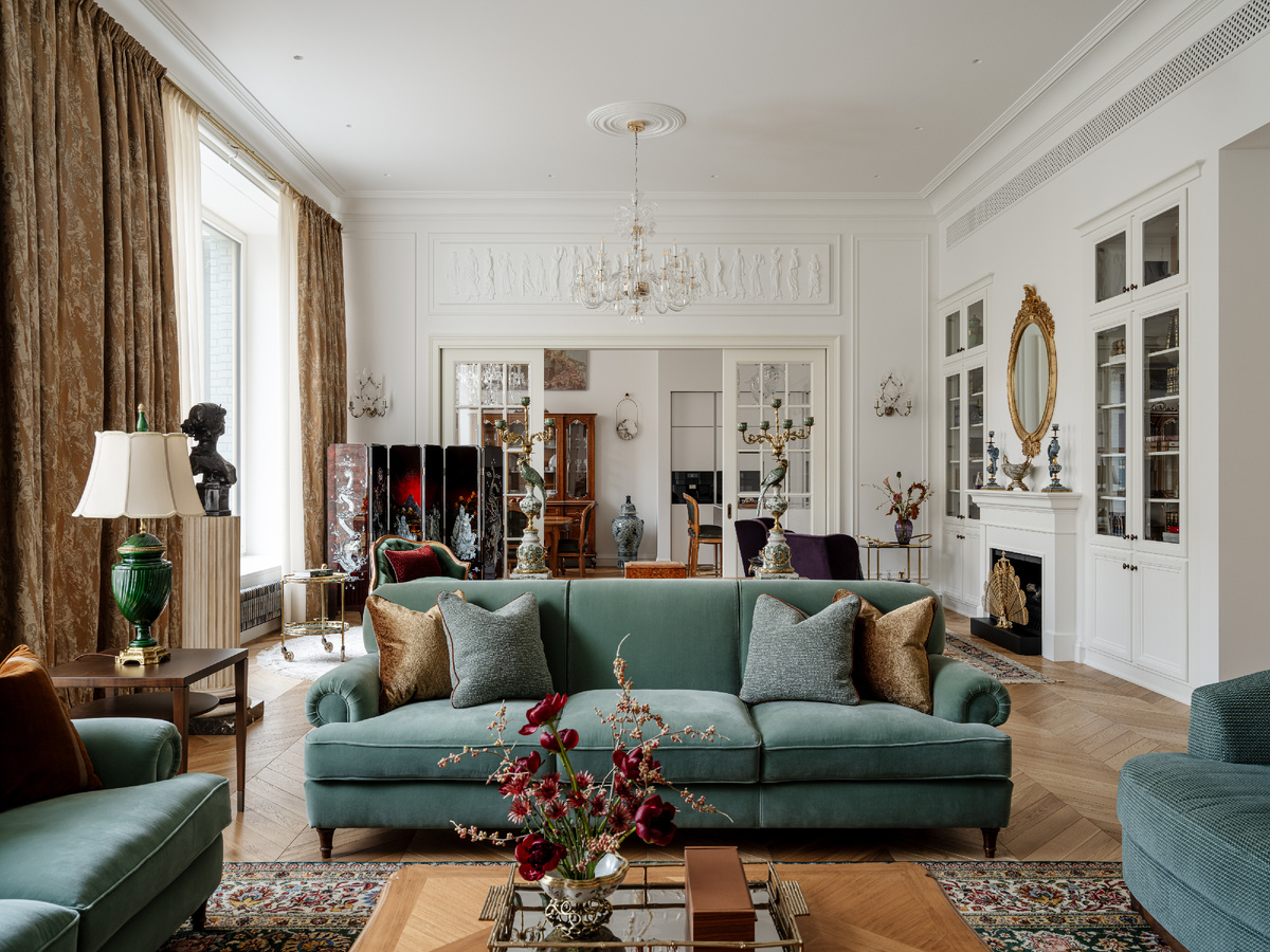 Гостиная и кухня на заднем плане. Мебель расставлена так, что в большой комнате возникли три независимые зоны. Берельеф выполнила Студия современного барельефа Леонида Кима.