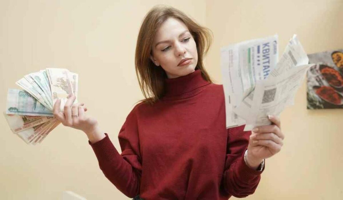     Девушка с квитанциями и деньгами. Источник: omsk.kp.ru Автор фото: Светлана Маковеева
