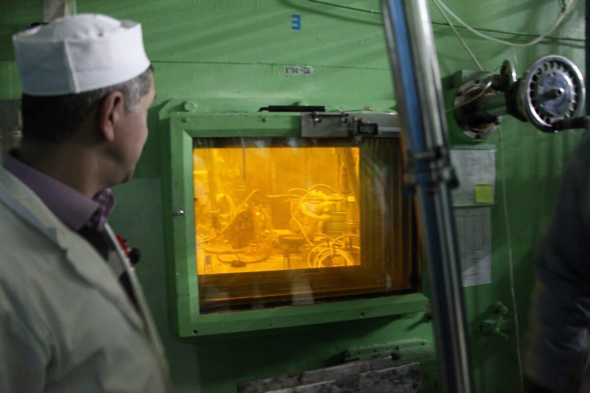    Так делают технеций-99 для больниц: после извлечения из реактора мишени с молибденом-99 перемещают в так называемую горячую камеру, где держат 1-2 суток для распада остальных изотопов, ненужных для медицинских целей. Перемещение будущих источников технеция осуществляют манипулятором операторы. От радиации их защищает толстая бетонная стенка камеры и стекло со специальными добавками, придающими ему желтый цвет. Без этой защиты находиться рядом было бы опасно / © НИФХИ специально для «Белатома»