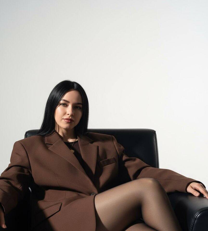 Девушка в пиджаке сидит в кожаном кресле — www.promtyi.com