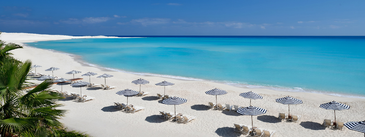Роскошный пляж египетского курорта с шезлонгами и зонтиками на берегу бирюзового Красного моря