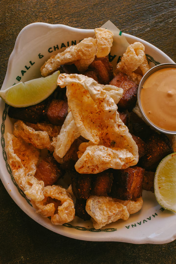 В ресторане Ball & Chain в Маленькой Гаване подают классические блюда кубинской кухни, такие как чичарронес - обжаренные свиные шкварки - и ропа вьеха: измельченная говядина, маринованная в соусе из помидоров, перца и лука.
