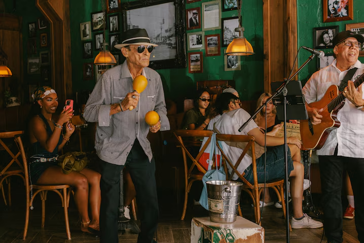 Трио Ball & Chain играет в ресторане в течение всей недели; Орест, играющий на маракасах, не работает в ресторане, но он приходит каждый день, чтобы поиграть, потанцевать и позировать для фотографий.