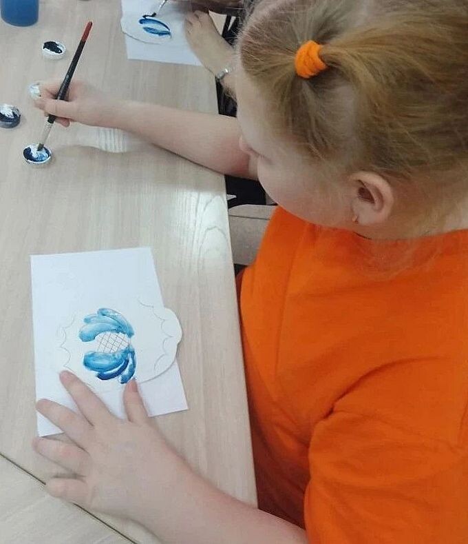 Девочка рисует цветок синей краской