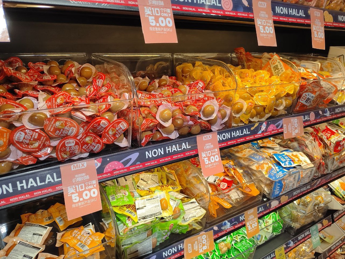   Полки с разнообразными снеками и сладостями, маркированные яркими ярлыками