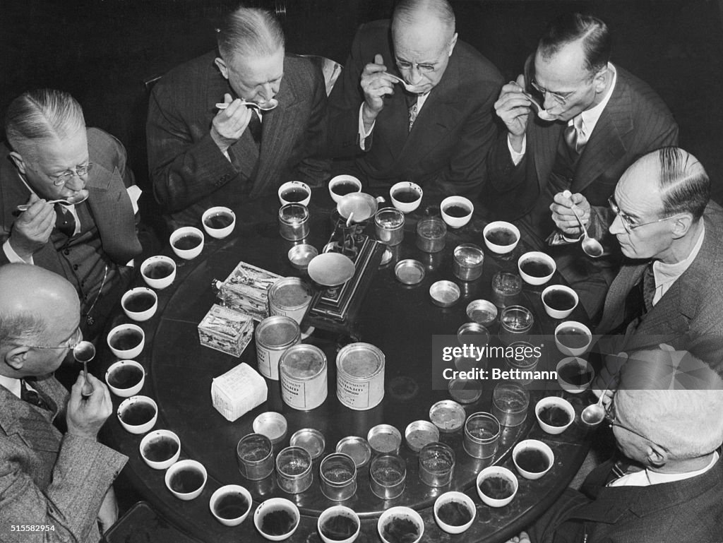 Members of the US Board of Tea Experts meet to taste teas. Left to right around the tasting table are J. Grayson Luttrell of Baltimore, Robert A. Lewis of Boston, George F. Mitchell of New York, Walter Hellyer of Chicago, Paul Ahrens of San Francisco, and William Harrington of New York and tea examiner.