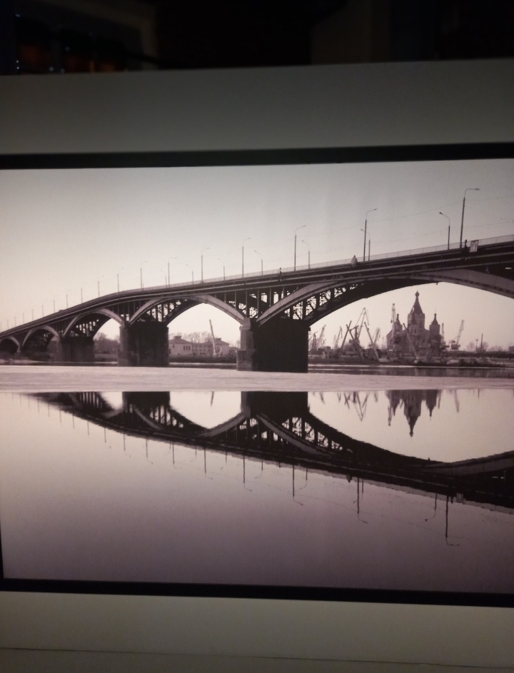 Таким мы увидели Нижний Новгород в 90-е, давно уже нет портовых кранов на Стрелке // фото автора с выставки А. Якубовича, 2025 г.