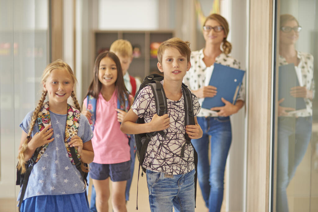    Pupils and teacher walking across the corridor Журналист