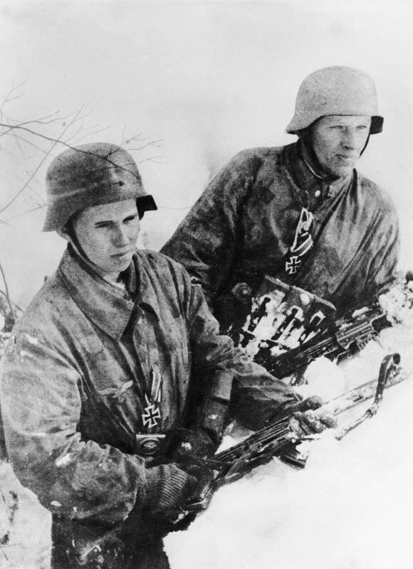 Немецкие солдаты — отец и сын, награжденные железными крестами, на позиции на окраине Бреслау (ныне Вроцлав, Польша). Вероятно, они из полка «Вель», сформированного из наземного персонала люфтваффе. Вооружены штурмовыми винтовками Sturmgewehr 44. Февраль 1945-го.  