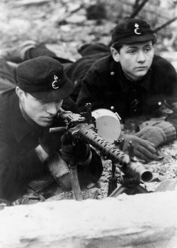 Фольксштурмисты, призванные из гитлерюгенда, обучаются навыкам стрельбы из пулемета MG34, в Берлине. Март-апрель 1945-го. 