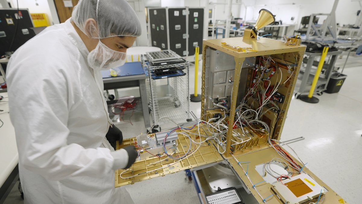 Инженер осматривает спутник Starcloud-1. Серебристый модуль внутри спутника оснащен графическим процессором NVIDIA H100.