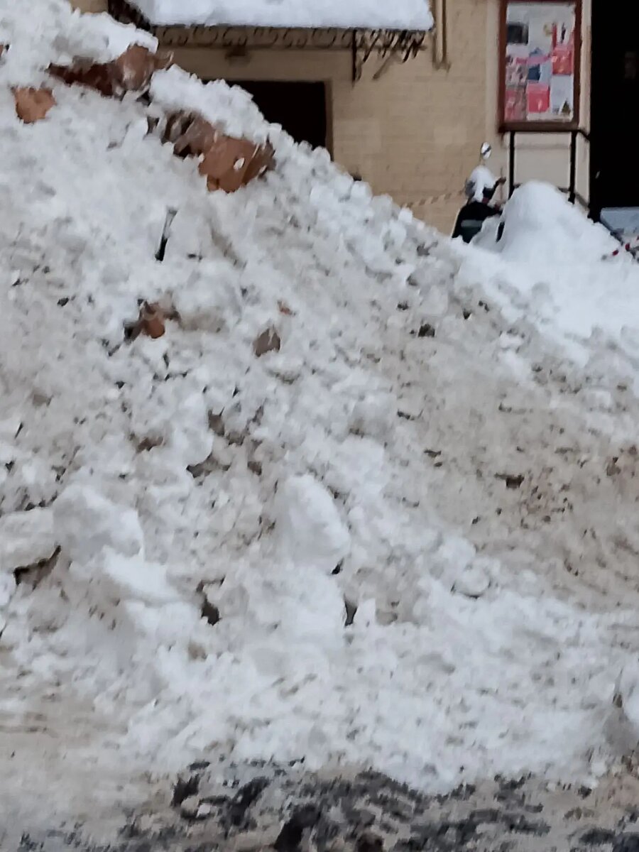 Москва. Снег сгребают прямо к стене дома.