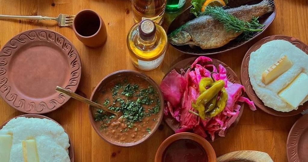 Классический абхазский обед: мамалыга, сыр, мясо двух видов, соленье, рыба, акуд (фасоль), асыдзбал (подлива из алычи), зелень и овощи