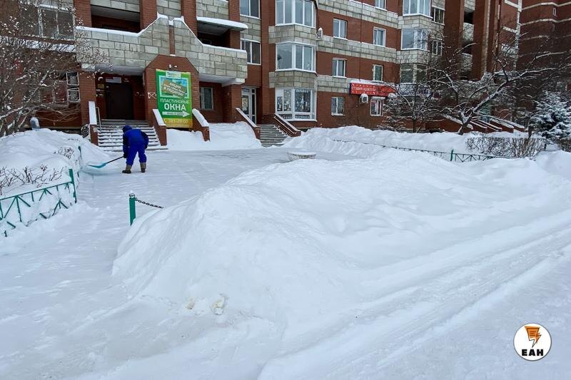    Человек чистит двор от снега