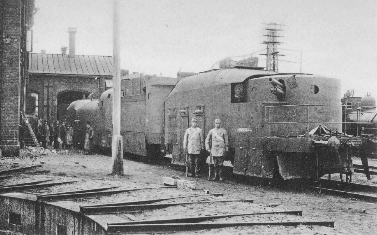 Двое солдат финской Белой гвардии фотографируются на фоне артиллерийского вагона трофейного советского бронепоезда "Имени Федора Раскольникова", захваченного в бою 24 апреля возле станции Сяйниё. Финляндия, Виипури, май 1918 года.