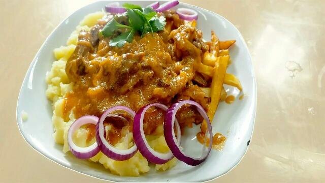 Аппетитный Бефстроганов на тарелке с гарниром
