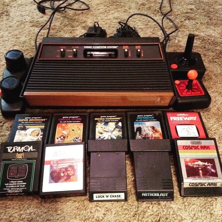 Игровая система Atari 2600 в комплекте с культовыми играми: Super Breakout, Missile Command, Cosmic Ark и другими.