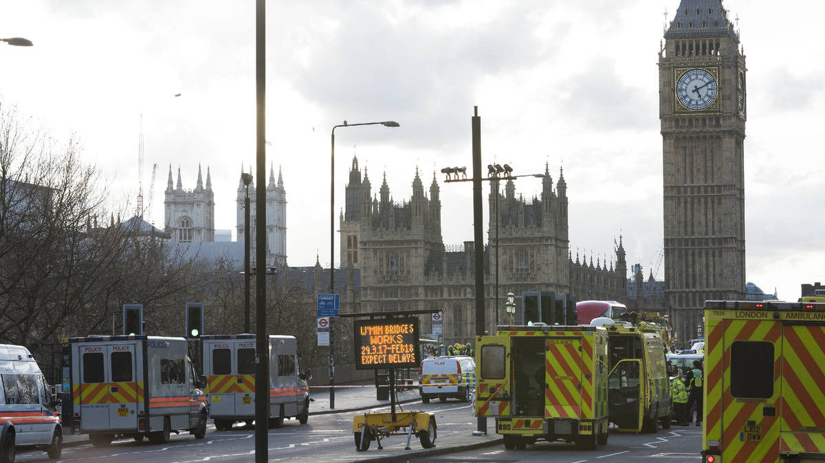 Машины скорой помощи ждут, пока медики оказывают помощь людям на Вестминстерском мосту, недалеко от Вестминстерского дворца в Лондоне, где заседает британский парламент.  22 марта 2017 года исламист Халид Масуд въехал на машине в пешеходов, находившихся на тротуаре вдоль южной стороны Вестминстерского моста и Бридж-стрит. В результате этого теракта более 50 человек получили ранения, четверо из них скончались. ©PA Images