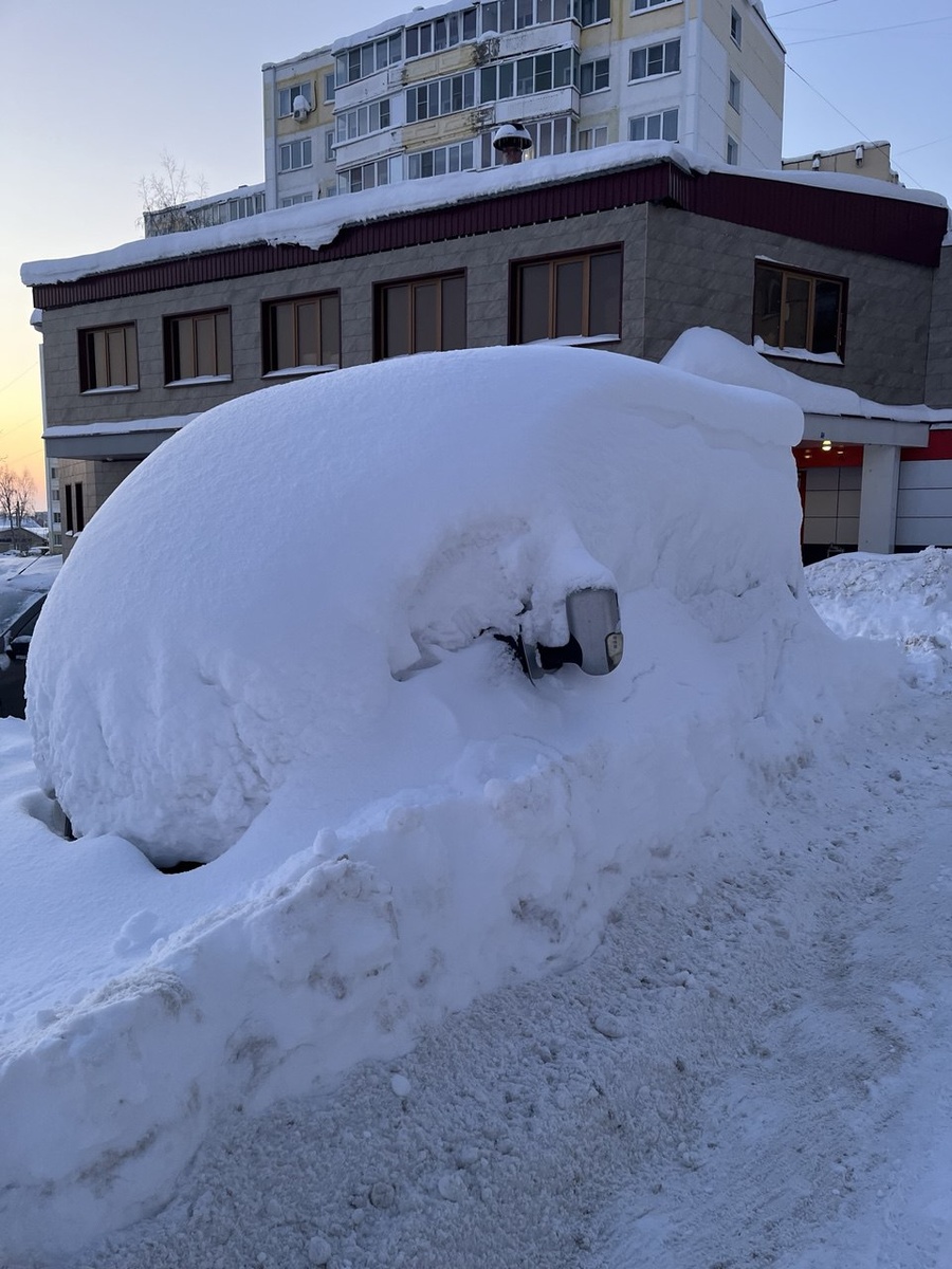 Это машину так завалило рядом с домом. Но это ещё вообще нормально. Рядом немного расчистили. И это ведь самый центр города. 