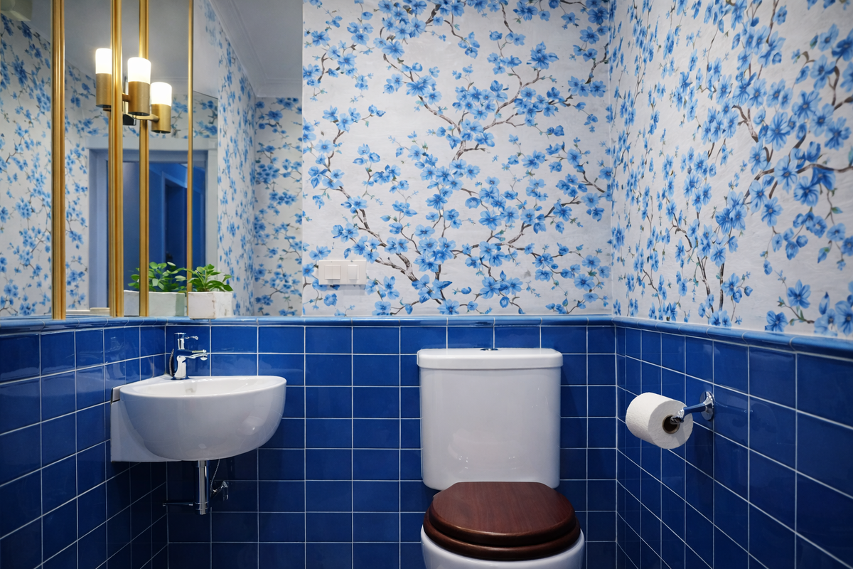 Цвет здесь проявляется уверенно и спокойно: насыщенная синяя плитка и цветочные обои создают яркий, цельный образ в небольшом пространстве.