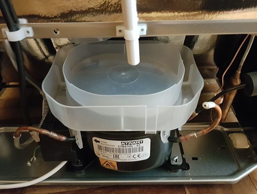 Вся талая вода из холодильника стекает в этот лоток и в нем испаряется за счет теплого компрессора