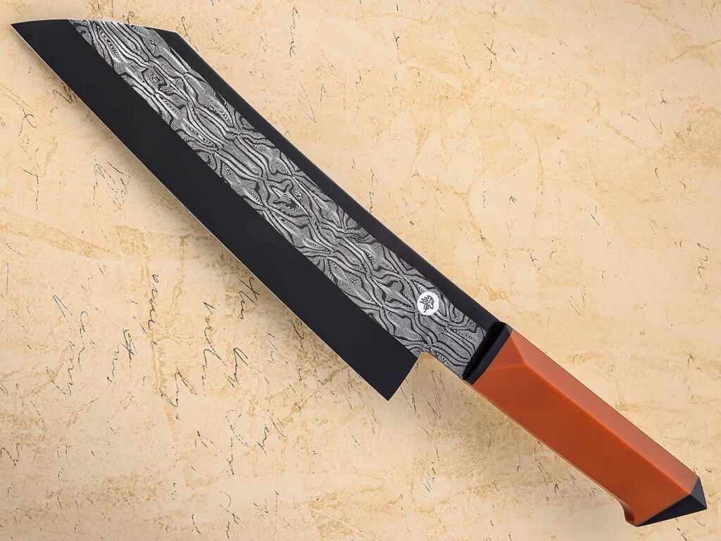 Рукоятка "сантоку" Aidan Garrity отличается параллельными боковыми гранями, которые повторяют ширину "рикассо". Внизу есть небольшой выступ для удобства захвата и элегантного вида. Клинок выполнен из мозаичного дамаска. Винтажные дополнения из butterscotch Micarta® обладают плоским поперечным сечением и оснащены распорками из G-10. Длина ножа составляет 14 дюймов.