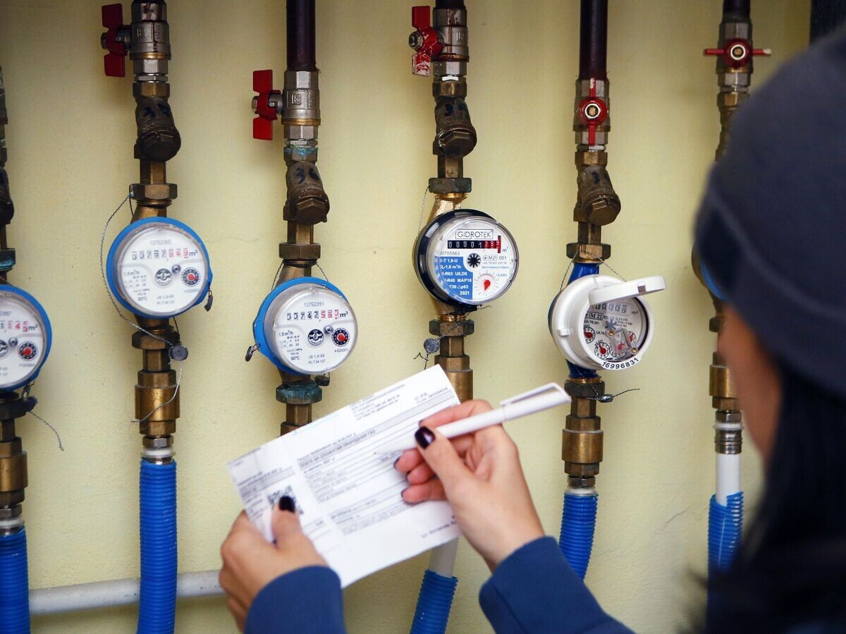    Девушка записывает показания счетчиков холодной и горячей воды | © РИА Новости / Стрингер