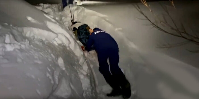 Трое тянут, один толкает. И всё равно спасателям лишь с большим трудом удаётся вытянуть сани с пострадавшим из снега / скриншот кадра видео МЧС России по Камчатскому краю